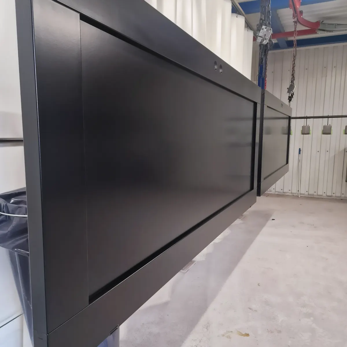 Matt svartlackerad panel hängande i lackeringshallen